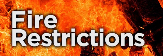 flame background with the words "fire restrictions" in the foreground